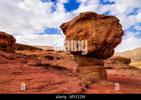 Geologische Felsformation namens Pilz mit roten Felsen in Timna Park in trockenen Sandstein Wüste Negev, Eilat, Israel umgeben. Winter sonniger Tag mit Stockfoto