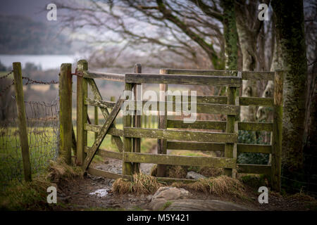 Eine alte kissing Gate durch einen Zaun auf einem Pfad über Keswick in Cumbria, Großbritannien. Stockfoto