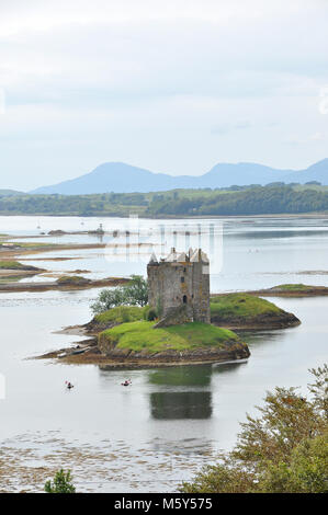 Schloss auf einer Insel mit Spiegelung, bewölktem Himmel und Bergen dahinter. Stalker Castle, Loch Laich, Argyll, Schottland Stockfoto