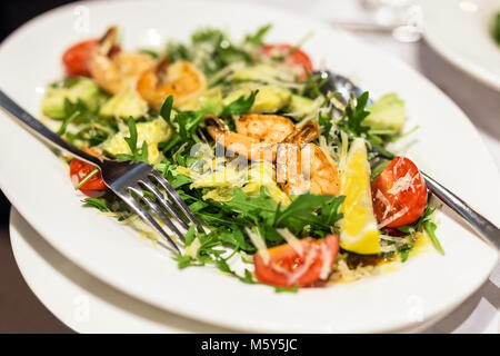 Platte mit gemischten Garnelen Salat. Teller mit Garnelen, Rucola, Tomaten und Käse. Leckeren, gesunden Mahlzeit. Stockfoto