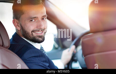 Unternehmer sitzen am Steuer eines Autos und Suchen auf dem Nocken Stockfoto