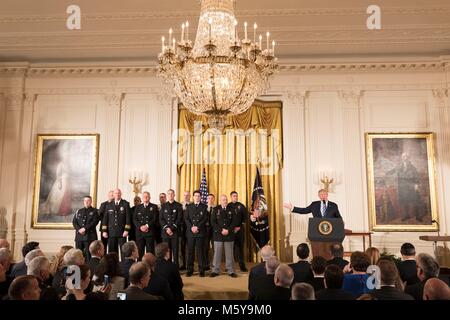 Us-Präsident Donald Trump präsentiert die Medaille von Valor Beamten während einer Zeremonie im East Room des Weißen Hauses Februar 20, 2018 in Washington, DC, zur Polizei. Stockfoto