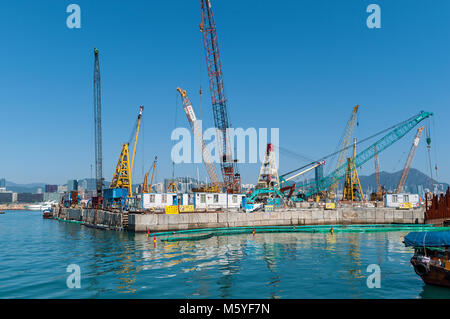 Hong Kong Januar 29, 2016: Baustelle auf dem Wasser und die Arbeit der Baukräne neben dem Hafen in Hongkong Stockfoto