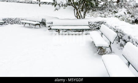 Winter in Paris im Schnee. Schnee bedeckt öffentlichen Holzbänken im Trocadero Garten. Stockfoto