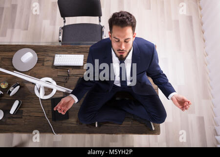 Junge Unternehmer Sitzen am Schreibtisch Yoga im Büro Stockfoto
