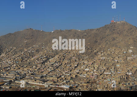 Luftaufnahme eines informellen Siedlung auf dem Hügel von Kabul in Afghanistan mit Sendemasten auf dem Berg in einem Abstand Stockfoto