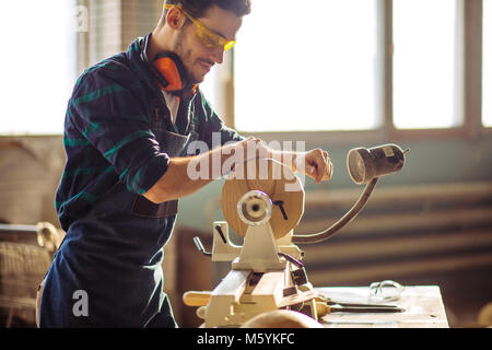 Attraktiver Mann anfangen, Holzarbeiten in der Schreinerei Stockfoto