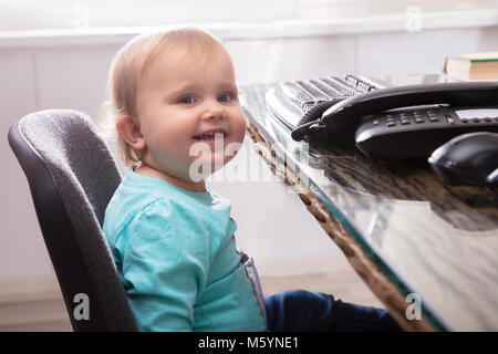 Portrait von Nett Lächelnden Mädchen sitzen auf Stuhl Stockfoto