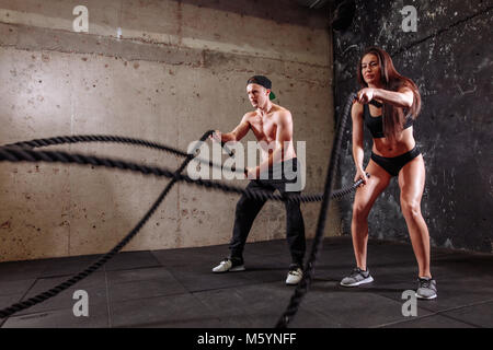 Frau und Mann Paar training zusammen kämpfen Seil Workout Stockfoto
