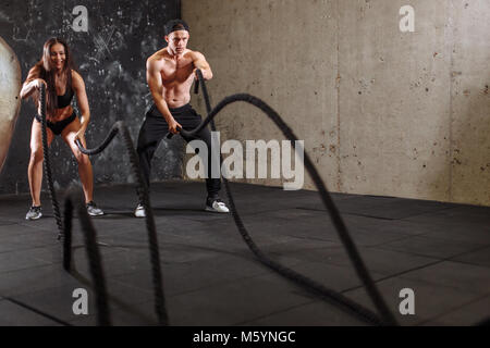 Frau und Mann Paar training zusammen kämpfen Seil Workout Stockfoto