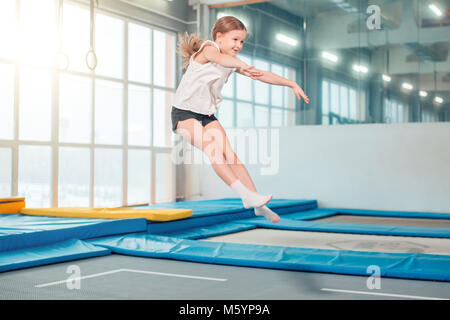 Mädchen springen hoch in Gestreifte Strumpfhosen auf Trampolin. Stockfoto