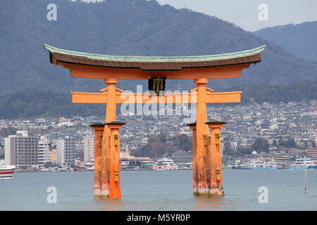 Itsukushima, auch als Miyajima bekannt, ist eine kleine Insel in der Bucht von Hiroshima. Nur offshore ist der Riese, orange Große Torii Tor. Stockfoto