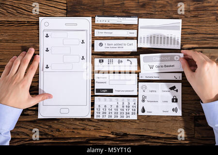 Erhöhte Ansicht einer Designer entwickeln Mobile auf Papier über Schreibtisch Stockfoto