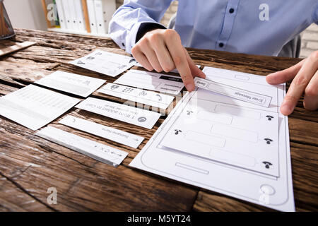In der Nähe von Designer Hand entwerfen Mobile Anwendung über Holz- Schreibtisch Stockfoto