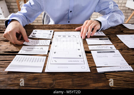In der Nähe von Designer Hand entwerfen Mobile Anwendung über Holz- Schreibtisch Stockfoto