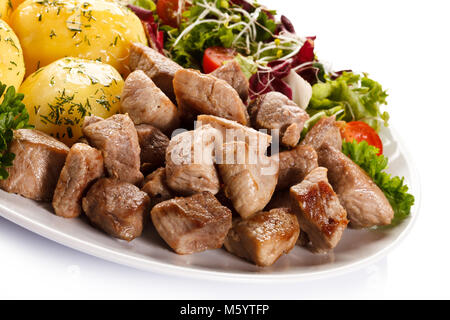 Gegrilltes Fleisch mit gekochten Kartoffeln und Gemüse auf Holz- Hintergrund Stockfoto