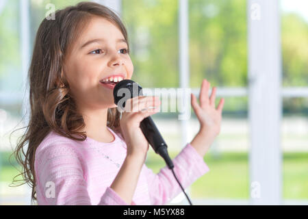 Wunderschönes kleines Mädchen mit Mikrofon