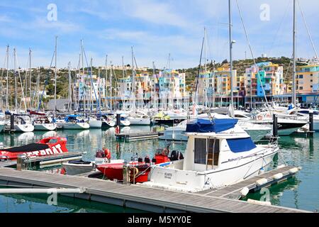 Yachten in der Marina mit Apartments und Waterfront Geschäfte auf der Rückseite, Albufeira, Algarve, Portugal, Europa. Stockfoto