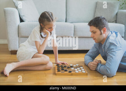 Vater und Tochter spielen Checkers Board Game. Stockfoto