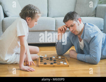 Vater und Tochter spielen Checkers Board Game. Stockfoto