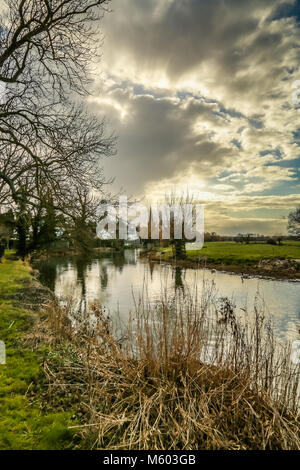 Das hübsche Dorf am Flussufer von Denton mit seinem Kirchturm im Winter Stockfoto