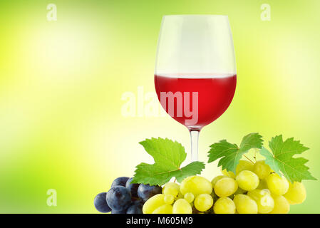 Bündel Weintrauben mit grüner Frische Blätter und Glas Rotwein auf grünem Hintergrund. Platz kopieren Stockfoto