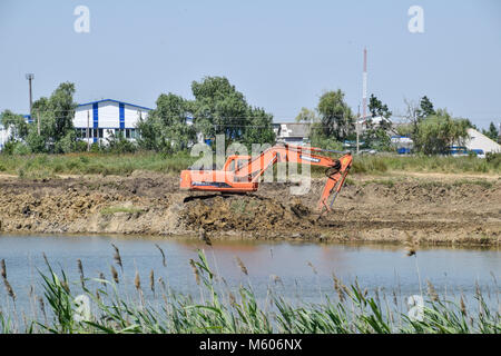 Bagger gräbt Ton in der Steinbruch mit Ton. Die Gewinnung von Ton. Stockfoto