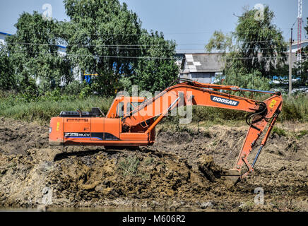 Bagger gräbt Ton in der Steinbruch mit Ton. Die Gewinnung von Ton. Stockfoto