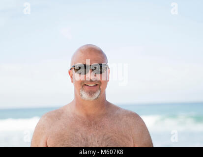 Lächelnd Glücklich glatzköpfige Mann mit Sonnenbrille am Strand in Mexiko Stockfoto