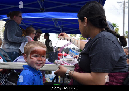 SAN DIEGO (Feb. 10, 2018) Navy Botschaftsrat erster Klasse Maria Moffett vom Navy Medical Center San Diego (NMCSD) Befehl Karriereratgeber Abteilung Gesicht malt zwei-jährige, Weston Wright als Walross, während eine Aufwertung Tag für Personal, Patienten und Familien. Die Gary Sinise Stiftung Gastgeber der jährlichen Gary Sinise unbesiegbaren Geist Veranstaltung, die eine Leistung durch die Lieutenant Dan Band, ein Mittagessen vom Grill von Robert Irvine Lebensmittel, und mehrere Veranstaltungen für alle Altersgruppen angeboten. (U.S. Marine Stockfoto