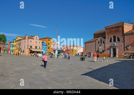 Burano, Italien. Blick auf die bunten Häuser in einem Quadrat mit Menschen an einem sonnigen Tag in Burano, eine liebenswürdige kleine Stadt voll von Kanälen, in der Nähe von Venedig. Stockfoto