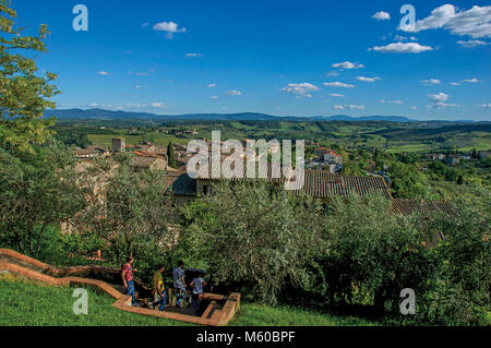 San Gimignano, Italien. Blick auf absteigende Treppe zwischen Bäumen in San Gimignano. Eine mittelalterliche Stadt mit mehreren Türmen. Stockfoto