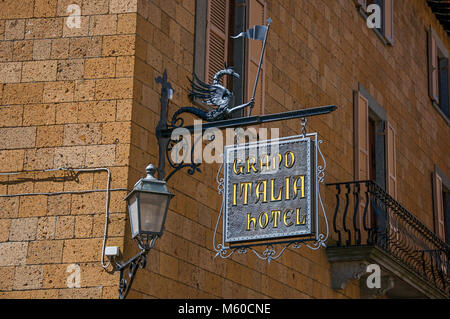 Orvieto, Italien. Close-up von aufwendigen Hotel Platte, aus Eisen, in Stein an der Wand und Lampe in Orvieto, eine schöne und gut erhaltene mittelalterliche Stadt klemmt Stockfoto