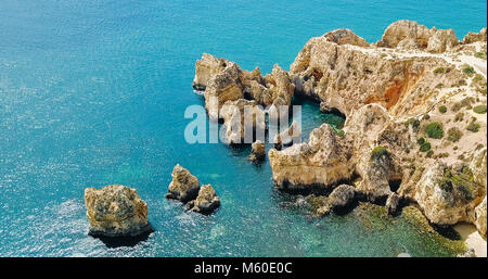 Luftaufnahme von Flying Drone von ruhigem blauen Wasser und Felsen formationen In der Algarve Lagos, Portugal Stockfoto