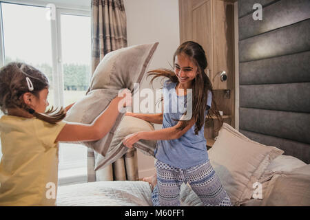 Zwei Schwestern haben eine Kissenschlacht in Ihrem Zimmer im Urlaub. Stockfoto