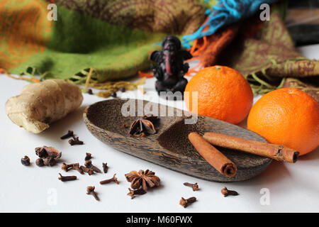 Winter noch Leben - zwei Mandarinen mit Spice auf hölzerne Schüssel (Ingwer, Sternanis, schwarzer Pfeffer, Zimt und Nelken) und kleine Statue angeordnet Stockfoto