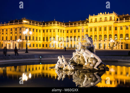 Schloss Schönbrunn und einer der Naiad Brunnen (Geister von Quellen und Flüssen) bei Nacht beleuchtet, Schönbrunn, Wien, Österreich. Stockfoto