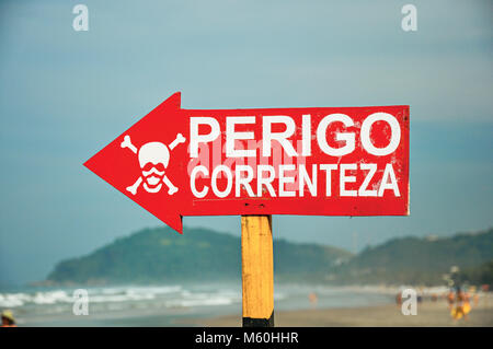 Warnschild, wo es auf Portugiesisch "GEFAHR" geschrieben steht, "Strom", an der Juquey Strand. Eine erstaunliche und tropischen Dorf im Bundesstaat São Paulo Küste. Stockfoto