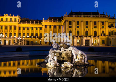 Schloss Schönbrunn und einer der Naiad Brunnen (Geister von Quellen und Flüssen) bei Nacht beleuchtet, Schönbrunn, Wien, Österreich. Stockfoto