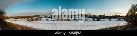 Fynn Tal, Suffolk, England. 27. Februar 2018. Panoramablick über Schnee beladene Felder auf einem späten Winter am Nachmittag. Viel von dem Schnee, der mit 'kam das Tier aus dem Osten 'kalten Wetter am Nachmittag Sonne geschmolzen. Die Sonne steht tief am Himmel auf der extremen Rechten Seite des Fotos. Dies schafft Lange weiche Schatten, die sich über die Felder von Bäumen, die von der Sonne beleuchtet werden. Die warmen Farben der Abend Himmel kann knapp über dem Horizont gesehen werden, niedrig in den Himmel. Dieses Panorama ist fast 180 Grad erstreckt sich eine Weite der Landschaft. Foto Stockfoto