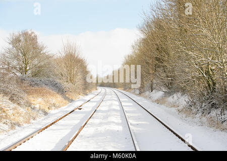 Gleise laufen durch Cherry Willingham, in der Nähe von Lincoln, im Schnee bedeckt wie Bäume die Route. Bild: Chris Vaughan Fotografie Stockfoto