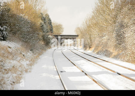 Gleise laufen durch Cherry Willingham, in der Nähe von Lincoln, im Schnee bedeckt wie Bäume die Route. Bild: Chris Vaughan Fotografie Stockfoto