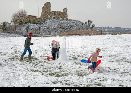 Hastings, Winter, East Sussex, Großbritannien, 27. Februar 2018. Eine Familie hat Spaß beim Bau eines Schneemanns am Schloss Hastings, in der verschneiten Landschaft bei Ladies Parlor. Stockfoto