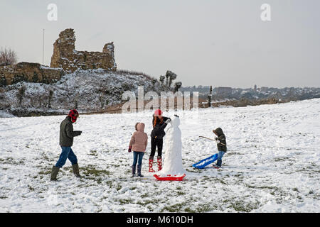 Hastings, Winter, East Sussex, Großbritannien, 27. Februar 2018. Eine Familie hat Spaß beim Bau eines Schneemanns am Schloss Hastings, in der verschneiten Landschaft bei Ladies Parlor. Stockfoto