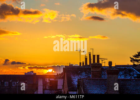 Northampton, Großbritannien 27. Februar 2018. Wetter. Bunte Ende an den Tag über die Dächer in einen goldenen Sonnenuntergang und ein helles Abstauben der Schnee auf den Dächern. Credit: Keith J Smith./Alamy leben Nachrichten Stockfoto