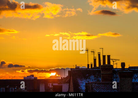 Northampton, Großbritannien 27. Februar 2018. Wetter. Bunte Ende an den Tag über die Dächer in einen goldenen Sonnenuntergang und ein helles Abstauben der Schnee auf den Dächern. Credit: Keith J Smith./Alamy leben Nachrichten Stockfoto