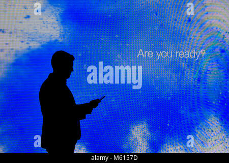 Barcelona, Spanien. 27 Feb, 2018. Ein Besucher wird über sein Handy vor dem großen Samsung Display auf dem Mobile World Congress zu sehen. Credit: Ramon Costa/SOPA Images/ZUMA Draht/Alamy leben Nachrichten Stockfoto