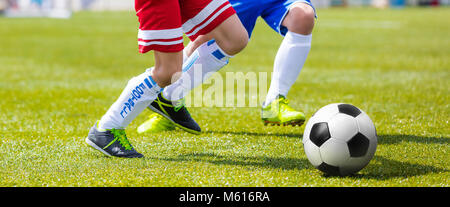 Football Player ausgeführt und treten Kugel auf Rasen. Fußball Stürmer und Verteidiger Wettbewerb Stockfoto