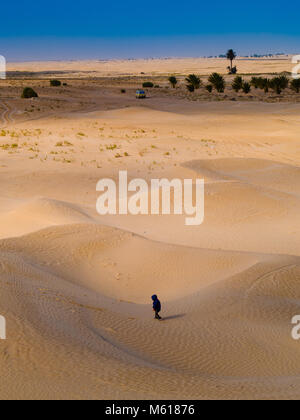 Kind in der Sahara spielt mit dem Sand der Dünen, touristische Urlaub Douz Tunesien Stockfoto