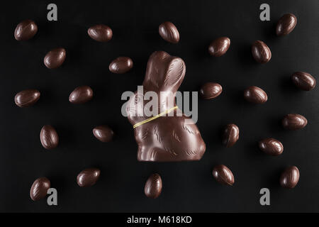 Leckere Schokolade Osterhasen und Eier auf dunklem Hintergrund Stockfoto
